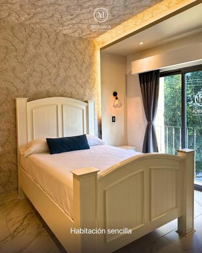 a bedroom with a large bed with a window at Hotel Boutique Casa Monarca in El Paraíso