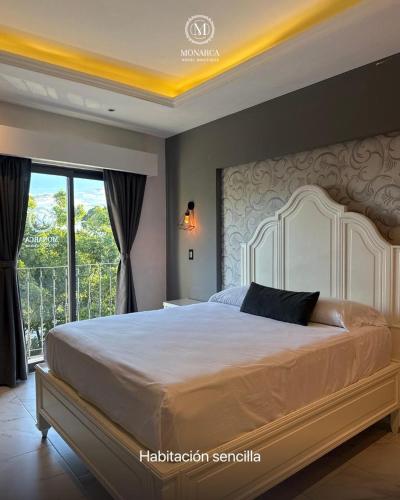 a bedroom with a large bed and a window at Hotel Boutique Casa Monarca in El Paraíso