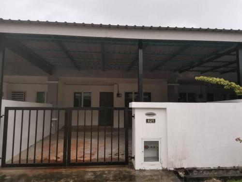 un bâtiment blanc avec une porte en face d'une maison dans l'établissement Puteri Resident In Stay, à Sungai Petani