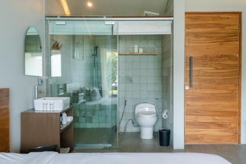 een badkamer met toilet en glazen douche bij Noya Hotel in Kubupenlokan