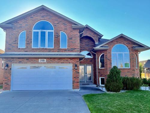 a large brick house with a large garage at Cozy and quiet room close to riverside in Windsor