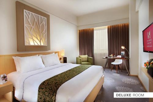 Postel nebo postele na pokoji v ubytování Swiss-Belinn Manyar