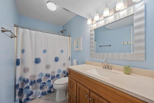 a bathroom with a sink and a toilet and a mirror at Annabella by the Sea- Ocean, Sound Views Retreat in North Topsail Beach