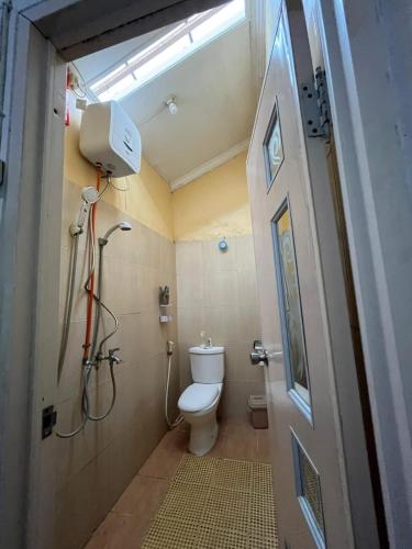 a bathroom with a toilet and a shower in it at Pendopo Andari Homestay in Yogyakarta