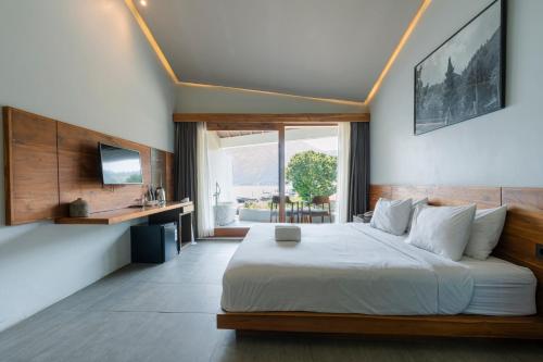 Un dormitorio con una cama grande y una ventana grande en Noya Hotel, en Kubupenlokan