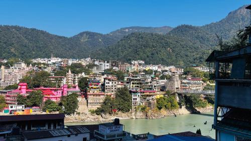 Una vista de una ciudad con un río y edificios. en Hotel Devraj, en Rishīkesh