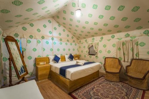 ジャイサルメールにあるTaj heritage camp& resortのテントの中にベッドがある寝室