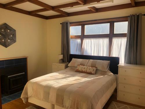 a bedroom with a bed in front of a window at Cambria Cottage in Nelson