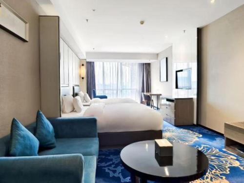 a hotel room with a bed and a living room at Nanning Champs Elysees Hotel in Nanning