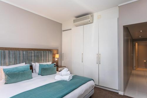 a bedroom with a large bed with green and white pillows at Harbour Bridge 401 by CTHA in Cape Town