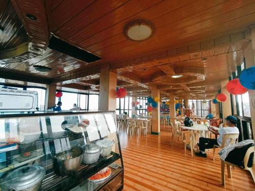 a restaurant with a counter and people sitting at tables at Mountain Pine Breeze in Sampong