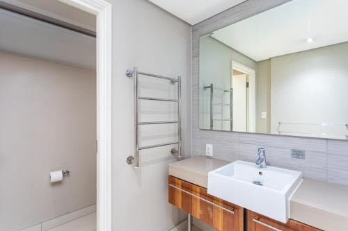 a bathroom with a sink and a mirror at Harbour Bridge 401 by CTHA in Cape Town