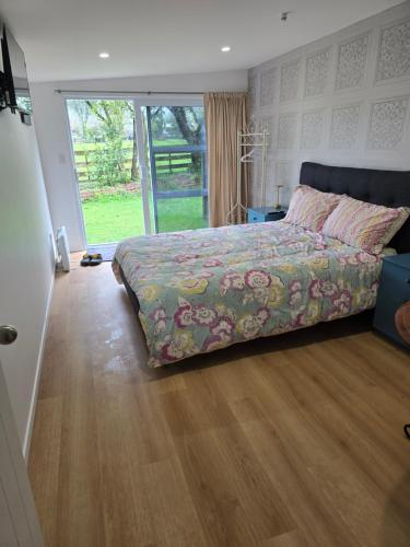 a bedroom with a bed and a wooden floor at Cold Ebb Mountain View Homestay 