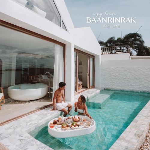 two people sitting in a swimming pool in a villa at Baan Rinrak Koh Larn บ้านรินรักษ์ เกาะล้าน in Ko Larn