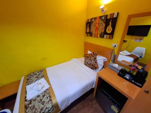 Un dormitorio con una cama y un escritorio con espejo. en Wow-Guesthouse soi 19, en Bangkok