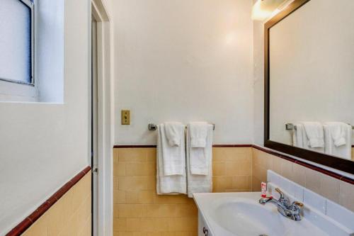 ein Badezimmer mit Waschbecken, Spiegel und Handtüchern in der Unterkunft OYO Gateway Motel Las Vegas North Strip/Fremont St. Area in Las Vegas