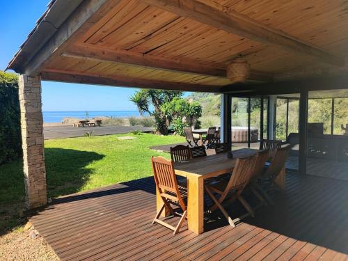 a wooden deck with a table and chairs on it at Maison Plage Mer in Cargèse