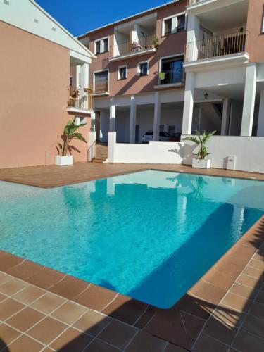 a swimming pool in front of a building at Apartamento Montesol in Sanet y Negrals
