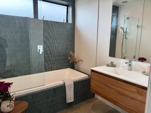 a bathroom with a tub and a sink at The Green Room in Queenstown Airport