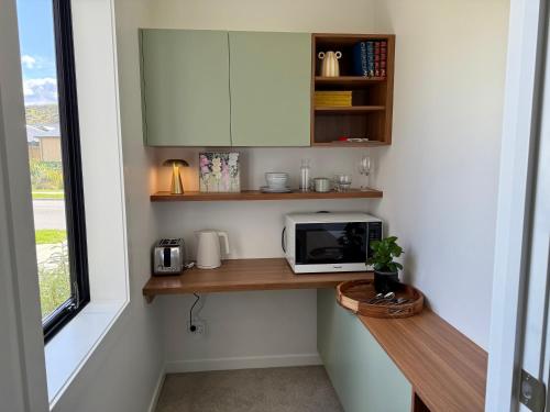 a kitchen with a counter with a microwave and a window at The Green Room in Queenstown Airport