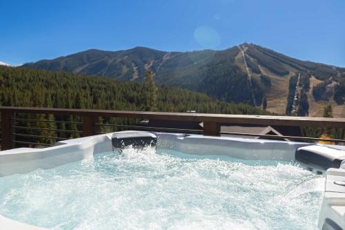 a jacuzzi tub with a view of a mountain at Summit Haus in Winter Park