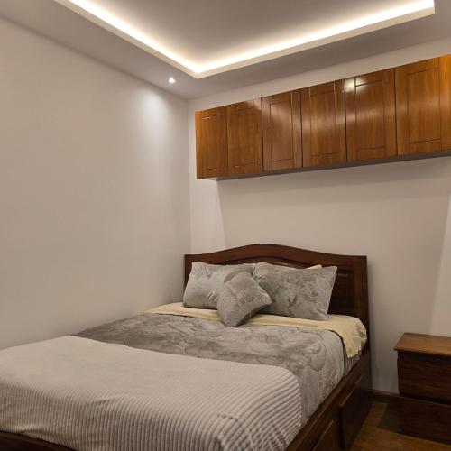 a bedroom with a bed and wooden cabinets at majesty beautiful suite in Cuenca