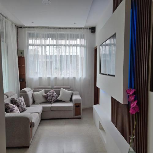 a living room with a couch and a window at majesty beautiful suite in Cuenca