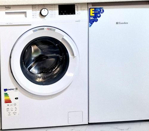 a white washing machine sitting next to a counter at Dostoievski 4 in Bălţi