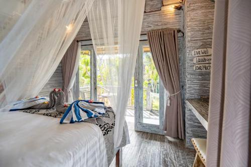 a bedroom with a bed with curtains and a window at Villa Cahaya - Ocean, sunset and volcano views, an island hideout in Nusa Ceningan