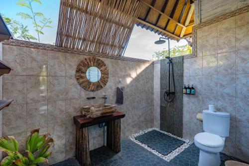 a bathroom with a shower with a toilet and a sink at Villa Cahaya - Ocean, sunset and volcano views, an island hideout in Nusa Ceningan