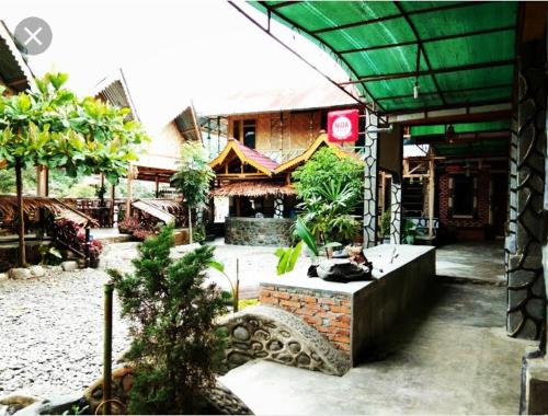 a building with a cat sitting in front of it at Tiga dara guest house jungle trekking in Bukit Lawang