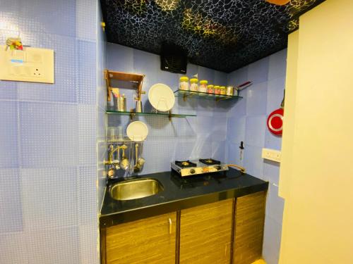 ムンバイにあるHotel Aksa Palaceの小さなキッチン(シンク、壁掛け鏡付)