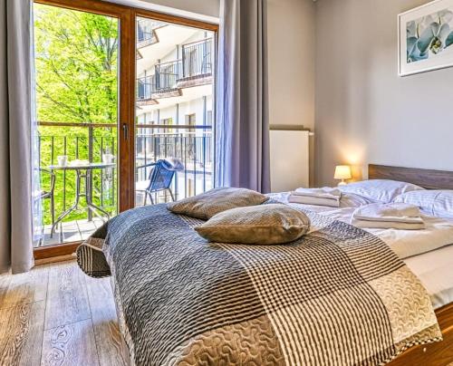 a bedroom with two beds and a large window at Apartament Góry Las in Szklarska Poręba