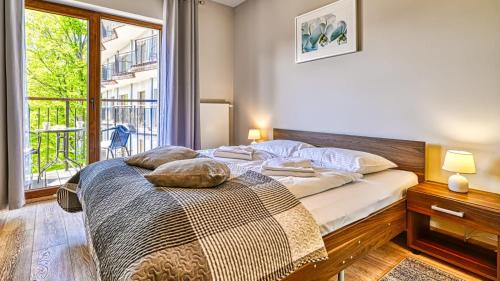 a bedroom with a bed and a large window at Apartament Góry i Las in Szklarska Poręba