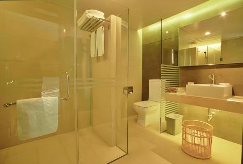 Un baño con ducha, inodoro y lavabo. en Wings Hotel, en Guangzhou