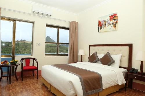 - une chambre avec un grand lit et une chaise rouge dans l'établissement Muong Thanh Lai Chau Hotel, à Pan Linh