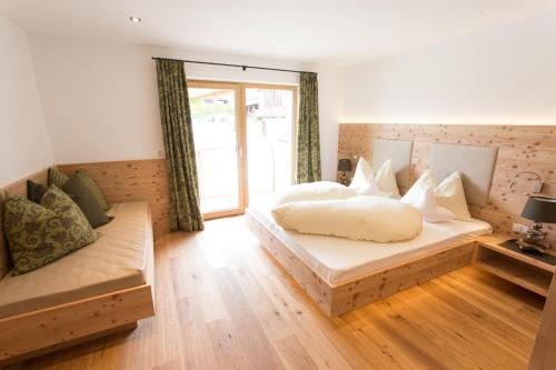 a bedroom with two beds and a couch at Bauernhofresidence Leierhof in Rodengo