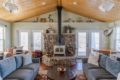 a living room with a stone fireplace with couches and a table at Lone Eagle Haven home in Mesa