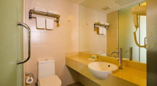 a bathroom with a sink and a toilet and a mirror at Jinjiang Inn Style Shenyang The Palace Huaiyuan Gate in Shenyang