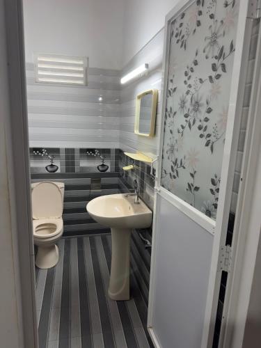 a small bathroom with a toilet and a sink at Mango House River Inn Negombo in Kochchikade