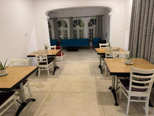 una sala da pranzo con tavoli e sedie in legno di Theodore Hotel - Negombo a Negombo