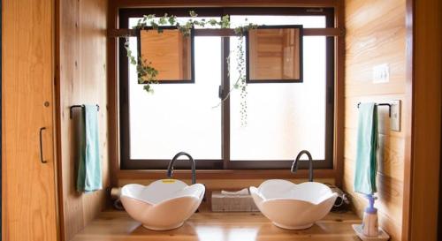 two white bowls sitting on a counter in front of a window at 大室山の麓ログハウスすくすく in Ito