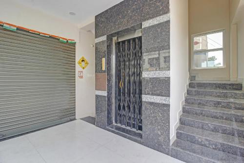 a building with a garage door and stairs at Hotel O Gvs Grand in Hyderabad