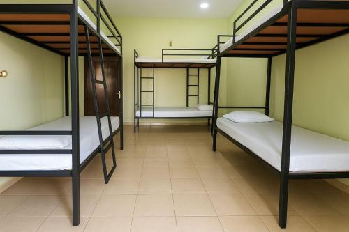 a room with three bunk beds and a tile floor at Comfy Stay in Badulla