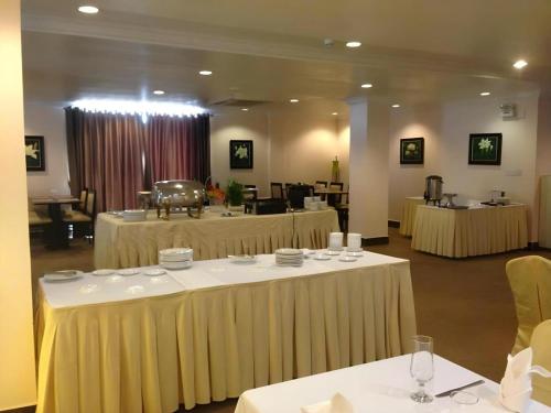 a room with several tables with chairs and tablesktop at Jun Yue Hotel in Phnom Penh