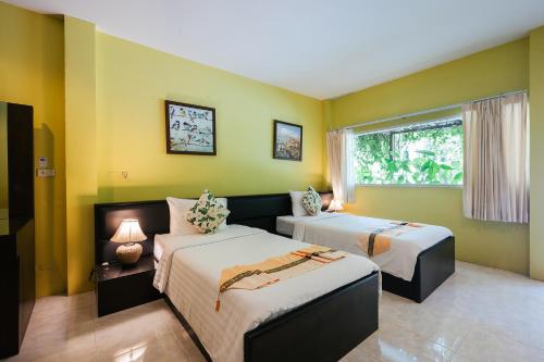 a room with two beds and a window at Thai Modern Resort & Spa "Newly Renovated" in Chalong