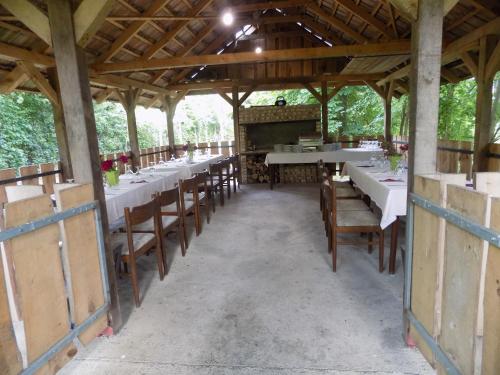 a dining room with tables and chairs in a pavilion at Bakterház Vendégház in Nagyvisnyó