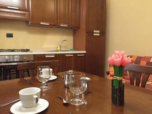 a table with a vase of pink flowers on it at Palazzo di Città in Saluzzo