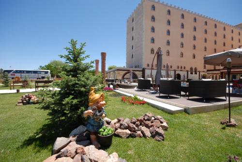 a statue sitting in the grass in front of a building at Suhan Cappadocia Hotel & Spa in Avanos