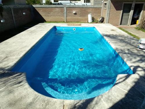 a blue swimming pool in the middle of a yard at Casa El Aromito Anisacate in Villa Anizacate